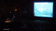 Ein Stummfilm mit musikalischer Untermalung wird in einer Kirche gezeigt. © Screenshot 