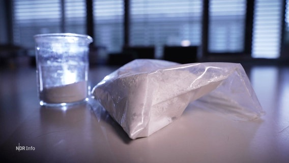 Ein weißes Pulver liegt in einem Plastikbeutel auf einem Labortisch. © Screenshot 