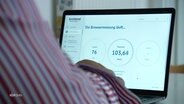 Ein Bürgermeister freut sich über die Zahlen seines Glasfaseranschlusses, die auf seinem Laptop zu sehen sind. © Screenshot 