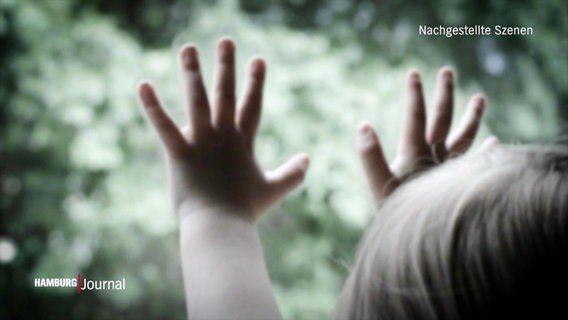 Nachgestellte Szene: ein Kleinkind hält seine Hände gegen eine Fensterscheibe. © Screenshot 