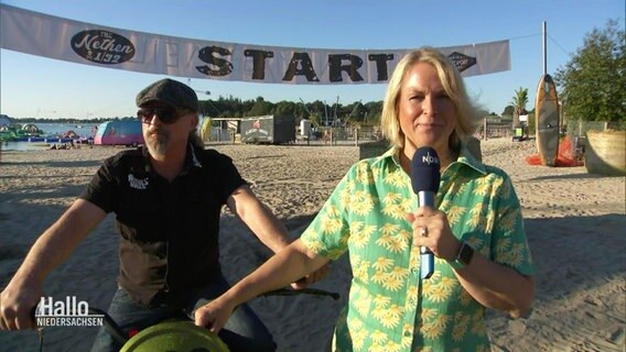 Anna Körber steht neben einem Bilker auf dem Gelände des Beachclubs Nethen. © Screenshot 