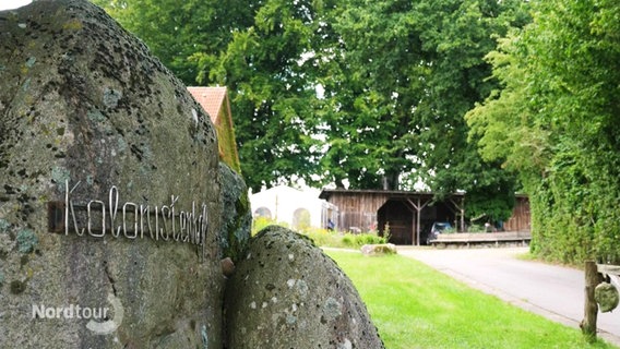 Auf einem Stein steht der Name eines alten Dorfes. © Screenshot 