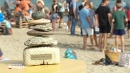 Ein Pokal aus Steinen mit der Aufschrift "Ditsch WM 2023" steht an einem Strand © Screenshot 