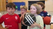 Kinder in einer Halle mit Basketbällen. © Screenshot 