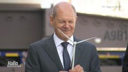 Olaf Scholz mit einem kleinen Windrad in der Hand und breitem Grinsen im Gesicht. © Screenshot 