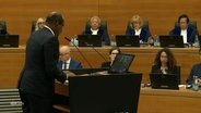 Eine Person in Anzug steht an einem Rednerpult. © Screenshot 