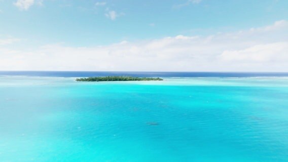 Eine Insel, eingerahmt von türkis-blauem Wasser. © Screenshot 