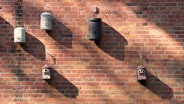 Brutkästen für Fledermäuse hängen an einer Hauswand. © Screenshot 
