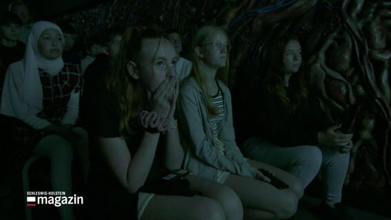 Schulkinder sehen sich einen Film in einem dunklem Raum an. © Screenshot 