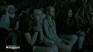 Schulkinder sehen sich einen Film in einem dunklem Raum an. © Screenshot 