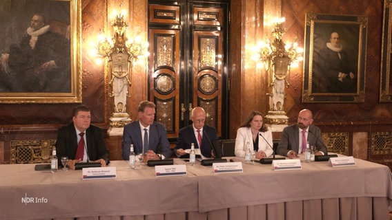 Ein Tisch mit dem Hamburger Bürgermeister, Senatoren und weiteren Personen im Rathaus. © Screenshot 