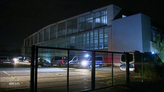 Einsatzfahrzeuge der Polizei vor einem Hangar. © Screenshot 