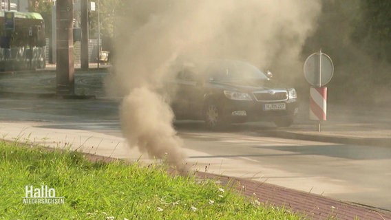 Aufsteigender Rauch, der aus einem Schacht neben einer Straße kommt. © Screenshot 