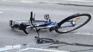 Ein umgekipptes Fahrrad liegt auf der Straße. © Screenshot 