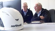 Mitarbeiter der Firma Northvolt sitzen an einem Tisch in einem Bürocontainer. © Screenshot 