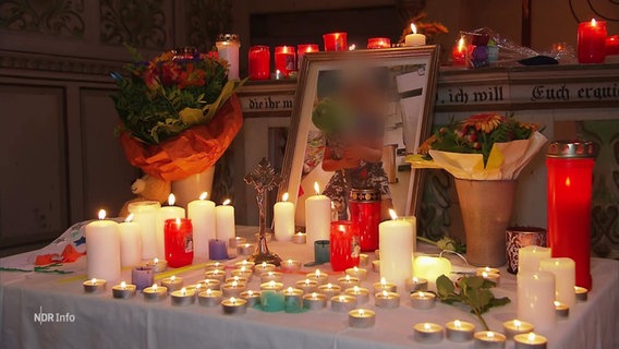 Kerzen liegen neben einem Bild in Gedenken an einen getöteten Jungen. © Screenshot 
