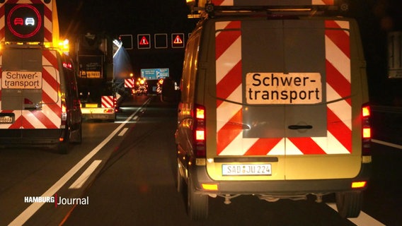 Ein Transporter mit der Aufschrift "Schwertransport" fährt bei Nacht über die Autobahn © Screenshot 