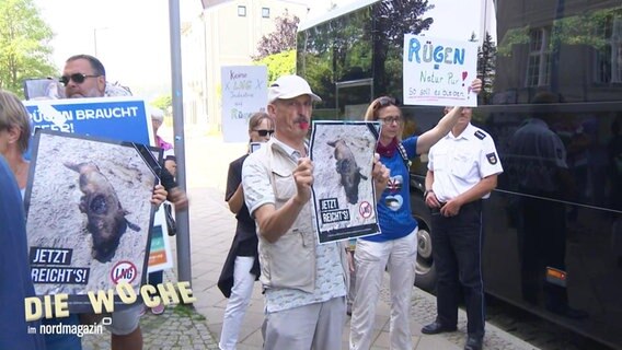 Menschen protestieren mit Schildern gegen ein LNG-Terminal auf Rügen. © Screenshot 
