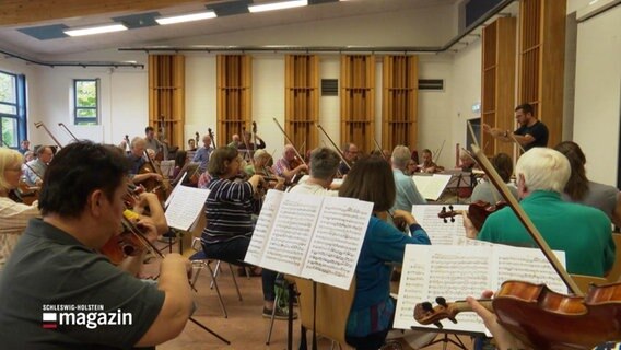 Orchester probt in einem großen Saal. © Screenshot 
