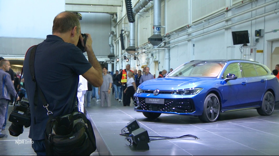 Mann fotografiert den neuen VW Tiguan auf der Betriebsversammlung des Konzerns.