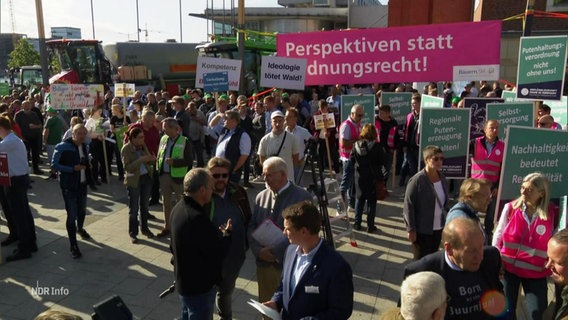 Eine Menschenmenge mit Plakaten und Schildern auf einem Platz. © Screenshot 