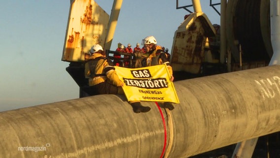 Menschen auf einer Pipline mit Plakat auf dem steht: Gas zerstört. © Screenshot 