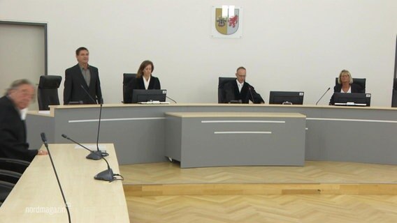 Menschen in Robe in einem Gerichtssaal. © Screenshot 