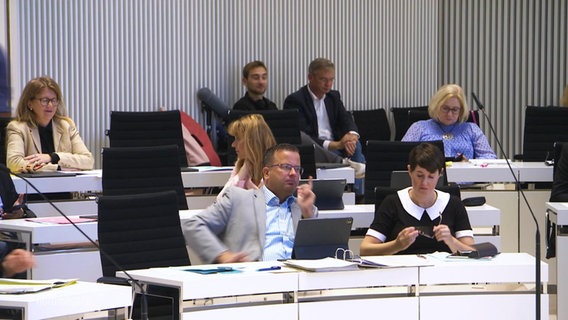 Menschen im Landtag auf Stühlen. © Screenshot 