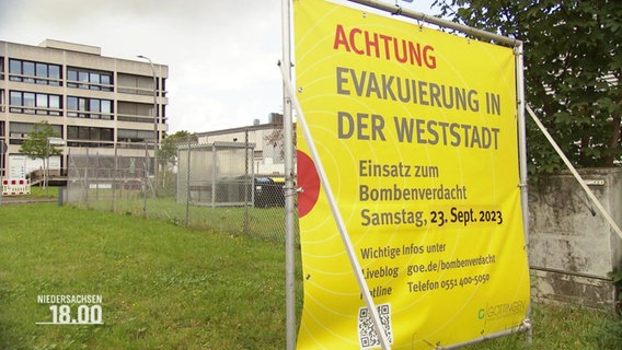 Ein großes, gelbes Plakat weißt auf eine Evakuierung wegen dem Fund von Bomben hin. © Screenshot 
