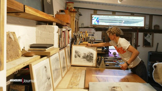 Künstlerin Bente Wolke stellt ein fertig Bild neben ihre Arbeitsfläche in ihrem Atelier. © Screenshot 