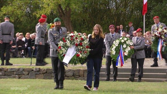 Blumenkränze werden von Soldaten getragen. © Screenshot 