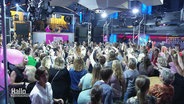Viele Frauen stehen in einer Disco auf der Tanzfläche und feiern. © Screenshot 