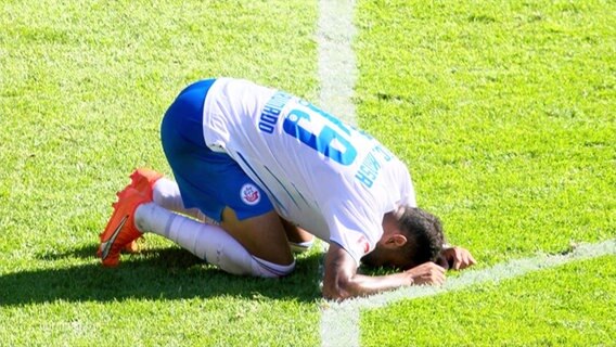 Ein Fußballer kniet auf dem Spielfeld. © Screenshot 