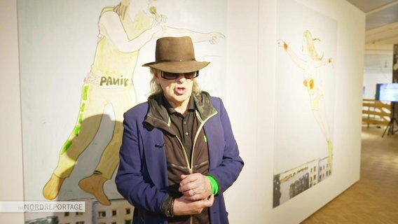 Udo Lindenberg vor einer seiner Illustrationen. © Screenshot 