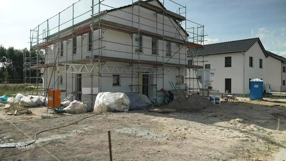 Ein Haus das gerade neu gebaut wird ist von Gerüsten umgeben. © Screenshot 