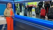Nachrichtensprecherin Juliane Möcklinghoff, im Hintergrund ein Bild von Menschen mit Koffern. © Screenshot 