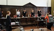 Journalisten fotografieren Richter und Staatsanwaltschaft im Gerichtssaal. © Screenshot 