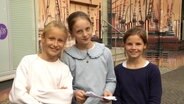 Drei junge Schülerinnen lächeln in die Kamera. © Screenshot 