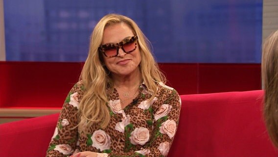 Anastacia mit Sonnenbrille auf dem roten Sofa. © Screenshot 