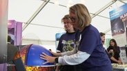 Zwei Personen machen ein Expriment beim "Highlights der Physik" in Kiel. © Screenshot 