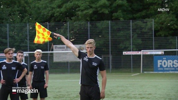 Nachwuchs-Schiedsrichter im Training. Einer von ihnen hält die Linienrichterfahne empor (Archivaufnahme). © Screenshot 