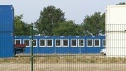Container hinter einem Zaun. © Screenshot 