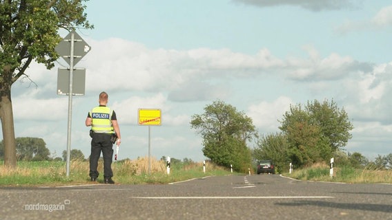 Ein Polizist steht an einer Landstraße. © Screenshot 