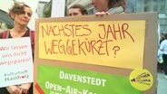 Menschen mit einem Protestplakat. © Screenshot 