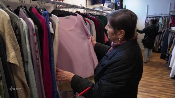 Eine Kundin schaut sich  einem Laden Klamotten an. © Screenshot 