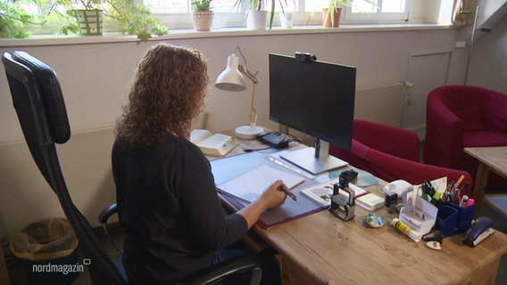 Eine Frau sitzt an einem Schreibtisch einer Beratungsstelle und telefoniert. © Screenshot 