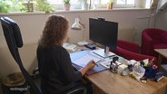 Eine Frau sitzt an einem Schreibtisch einer Beratungsstelle und telefoniert. © Screenshot 