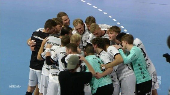 Spieler des THW Kiel stehen in einem engen Kreis auf dem Spielfeld. © Screenshot 