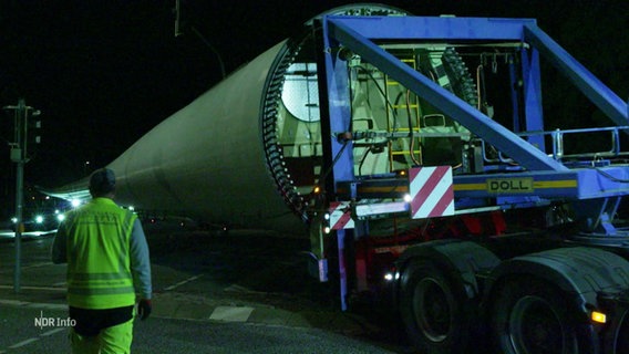 Ein Schwerlastransporter transportiert Teile eines Windrades. © Screenshot 