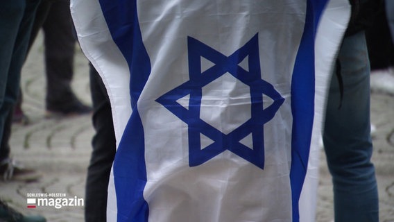 Ein Junge trägt eine Israelfahne über dem Rücken. © Screenshot 